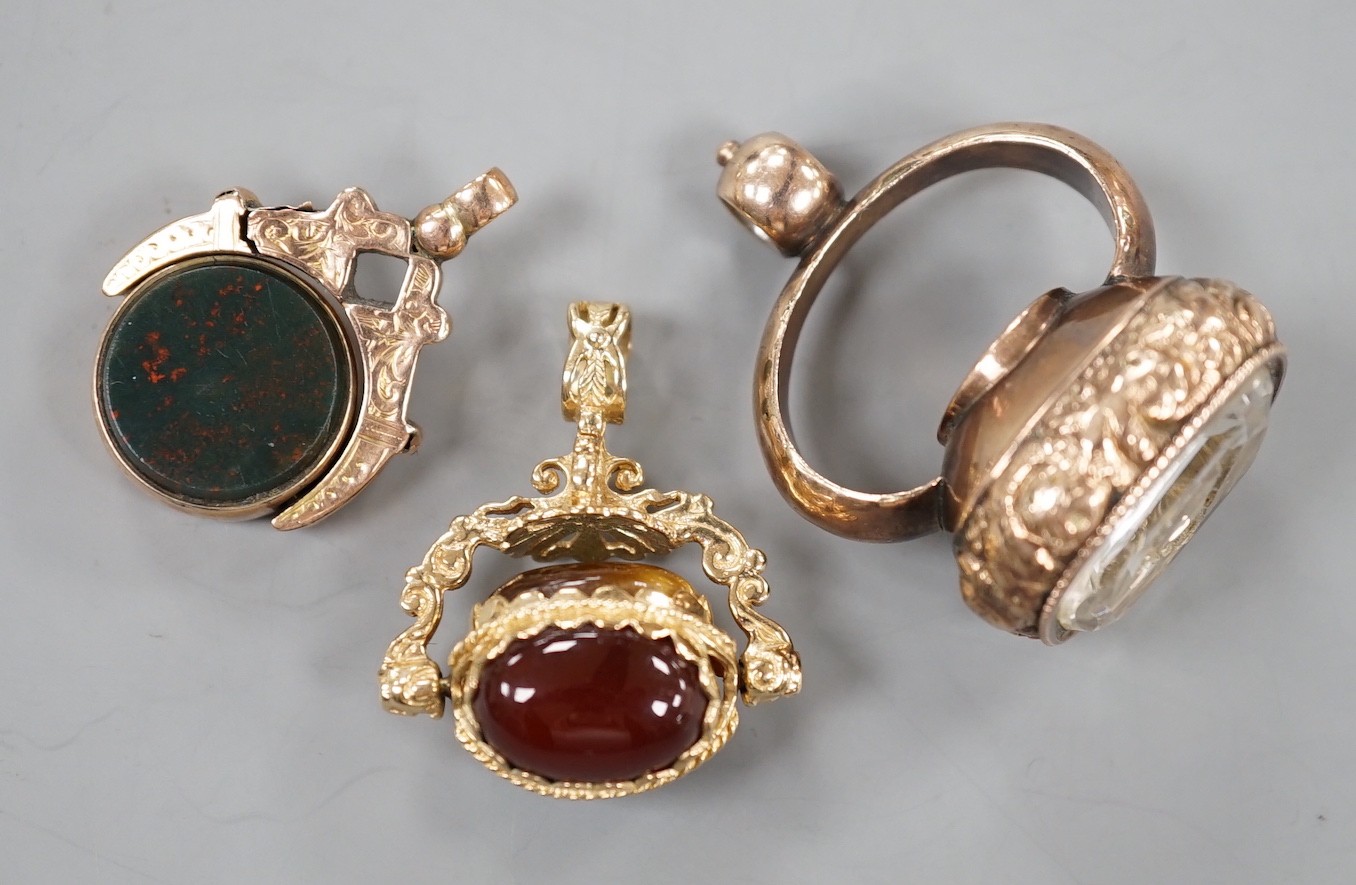 A late 19th/early 20th century yellow metal overlaid and foil backed rock crystal set fob seal with inset compass, 37mm and two other later hardstone set fob seals.
